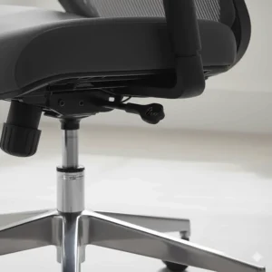 A detailed shot of a Class-3 gas lift lever for seat height adjustment on a cheap ergonomic chair.