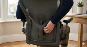 Close-up of adjustable lumbar support on an affordable ergonomic chair, essential for good posture while working from home.