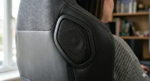 Close-up of integrated high-definition speakers in the headrest of a fabric gaming chair for immersive audio.