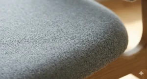 Close-up of the breathable, textured grey fabric upholstery on a Scandinavian ergonomic office chair.