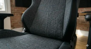 Macro view of the reinforced seams and blue hexagonal stitching pattern on the backrest of a quality gaming chair.