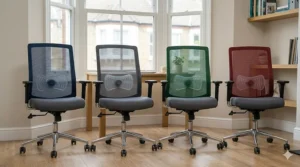 A photorealistic photograph showcasing four identical ergonomic office chairs in navy blue, charcoal grey, forest green, and burgundy red, demonstrating the range of choice under natural British daylight.