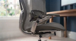 Person sitting upright in an ergonomic computer chair with adjustable lumbar support.
