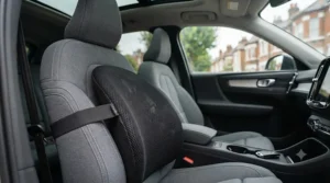 Side profile of a mesh back support cushion securely fitted to a car seat using adjustable elastic straps.