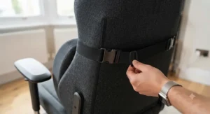 Rear view of the lumbar cushion being secured to the gaming chair backrest with its dual, adjustable elastic straps and quick-lock buckles.