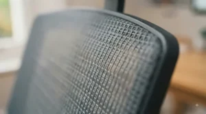 Macro texture shot of durable, high-tensile black mesh fabric used on a heavy-duty computer chair.