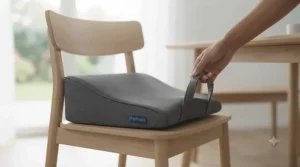 A hand holding the integrated handle of the grey wedge cushion, demonstrating its portability and ease of transport.