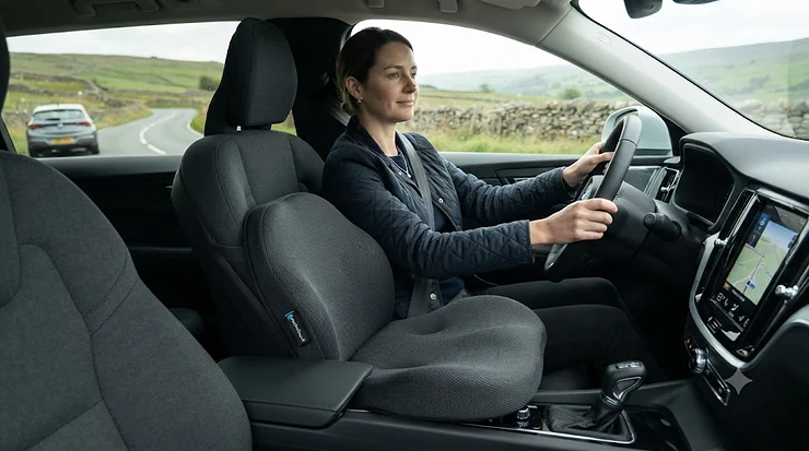 Comfortable grey memory foam seat cushion for long car journeys fitted in a driver's car seat. seat cushion for long car journeys seat cushion for long car journeys